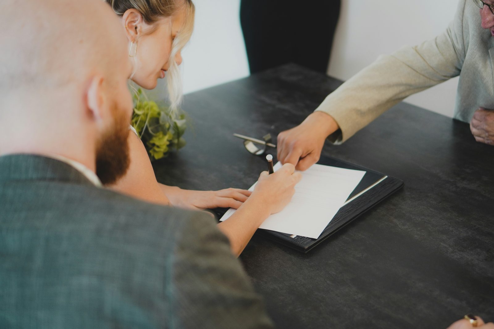 A couple signing papers with their agent