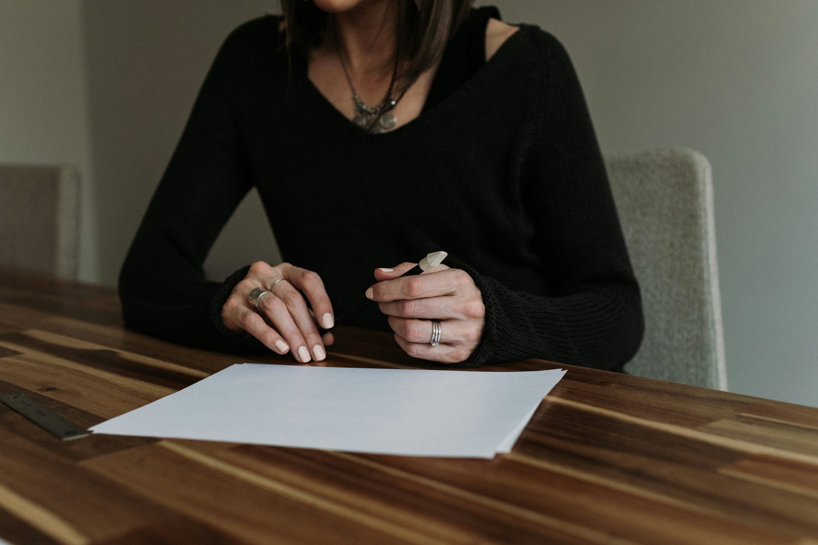 A woman at a table preparing to sign a document